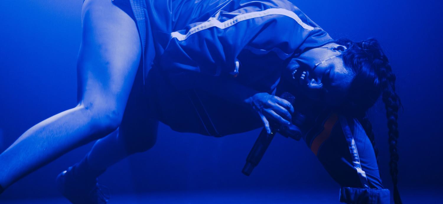 Baby Volcano dancing on stage in blue light
