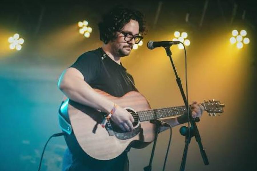 Daniel B playing guitar while performing